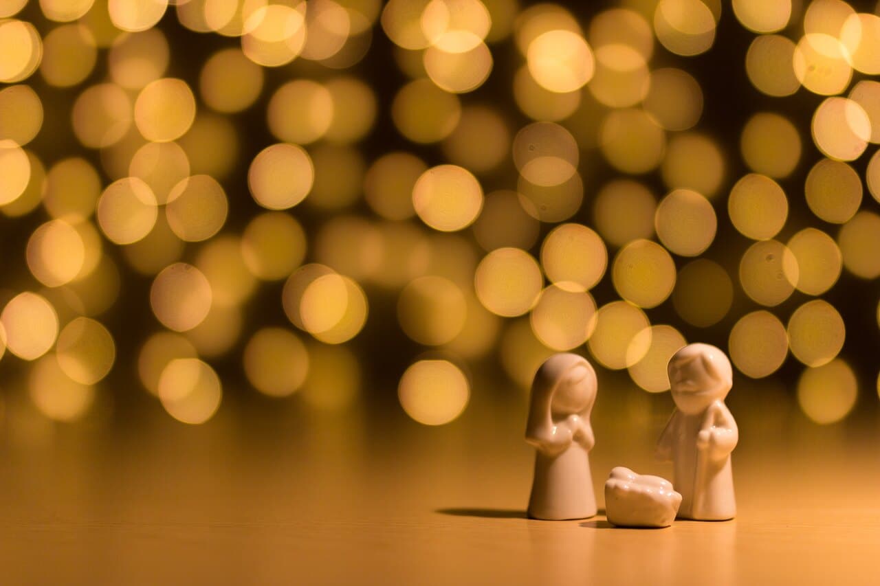 Nativity figurines with golden bokeh lights background