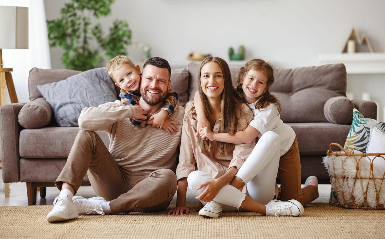 Family sitting together on the living room floor