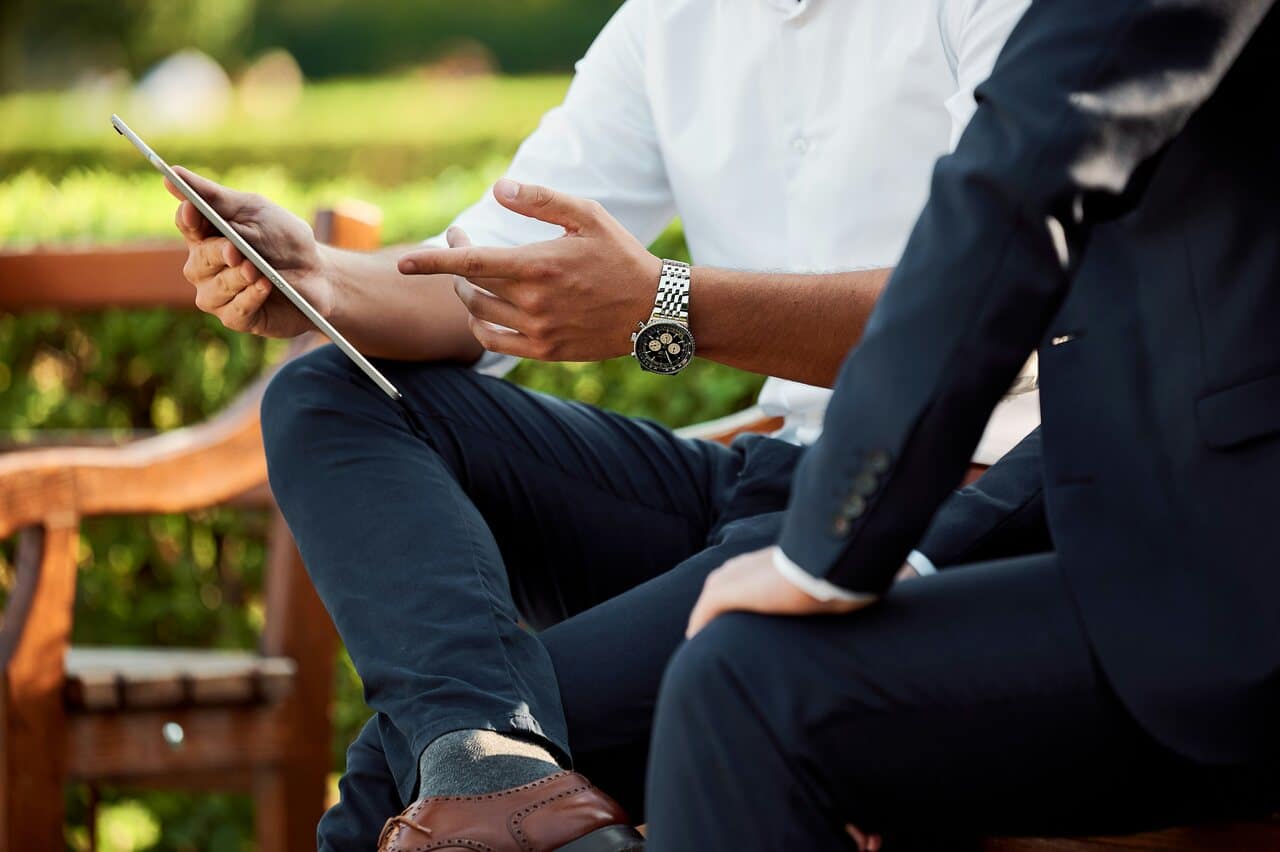 Two people discussing over a tablet outdoors